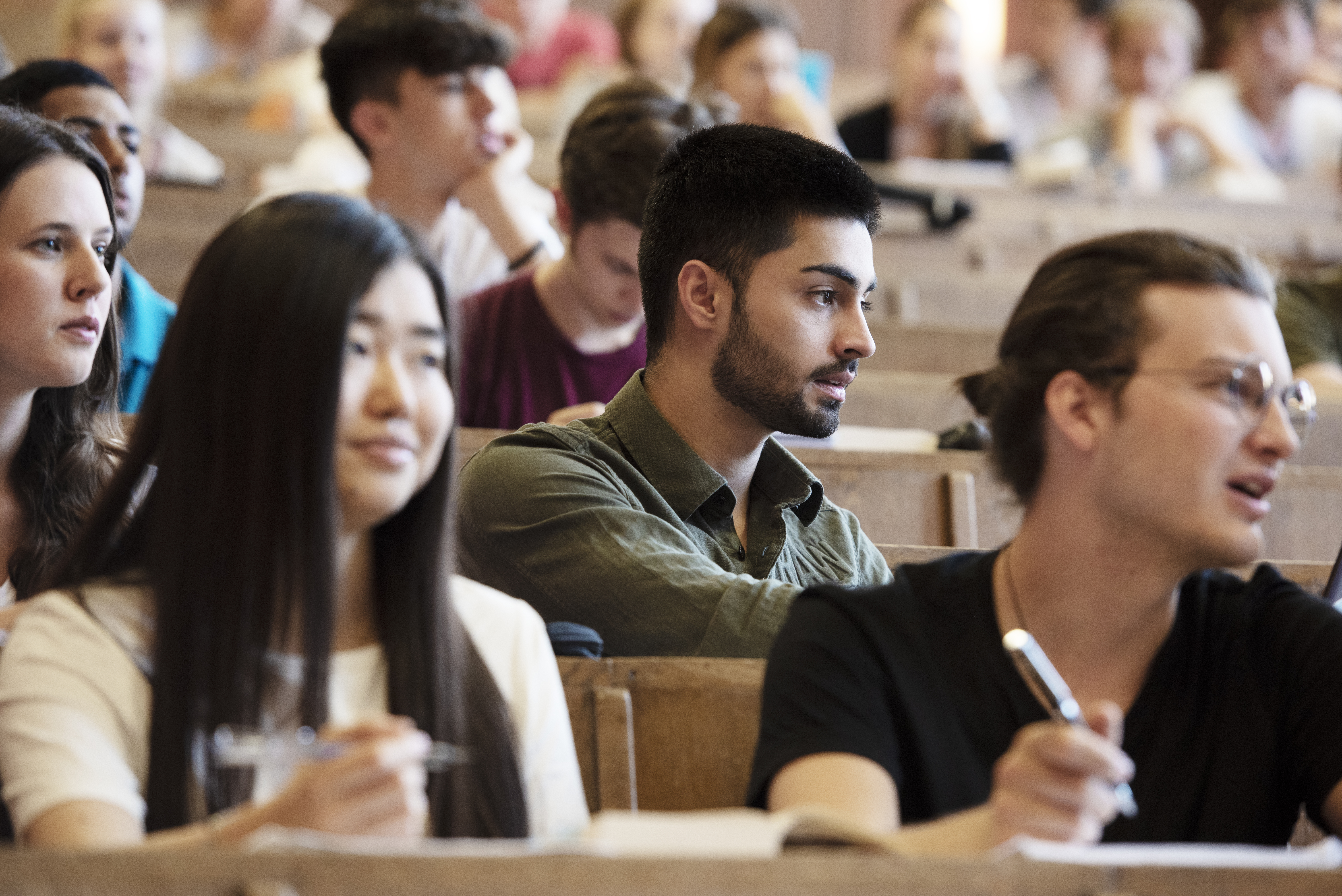 students sitting in a lecture hall and listening