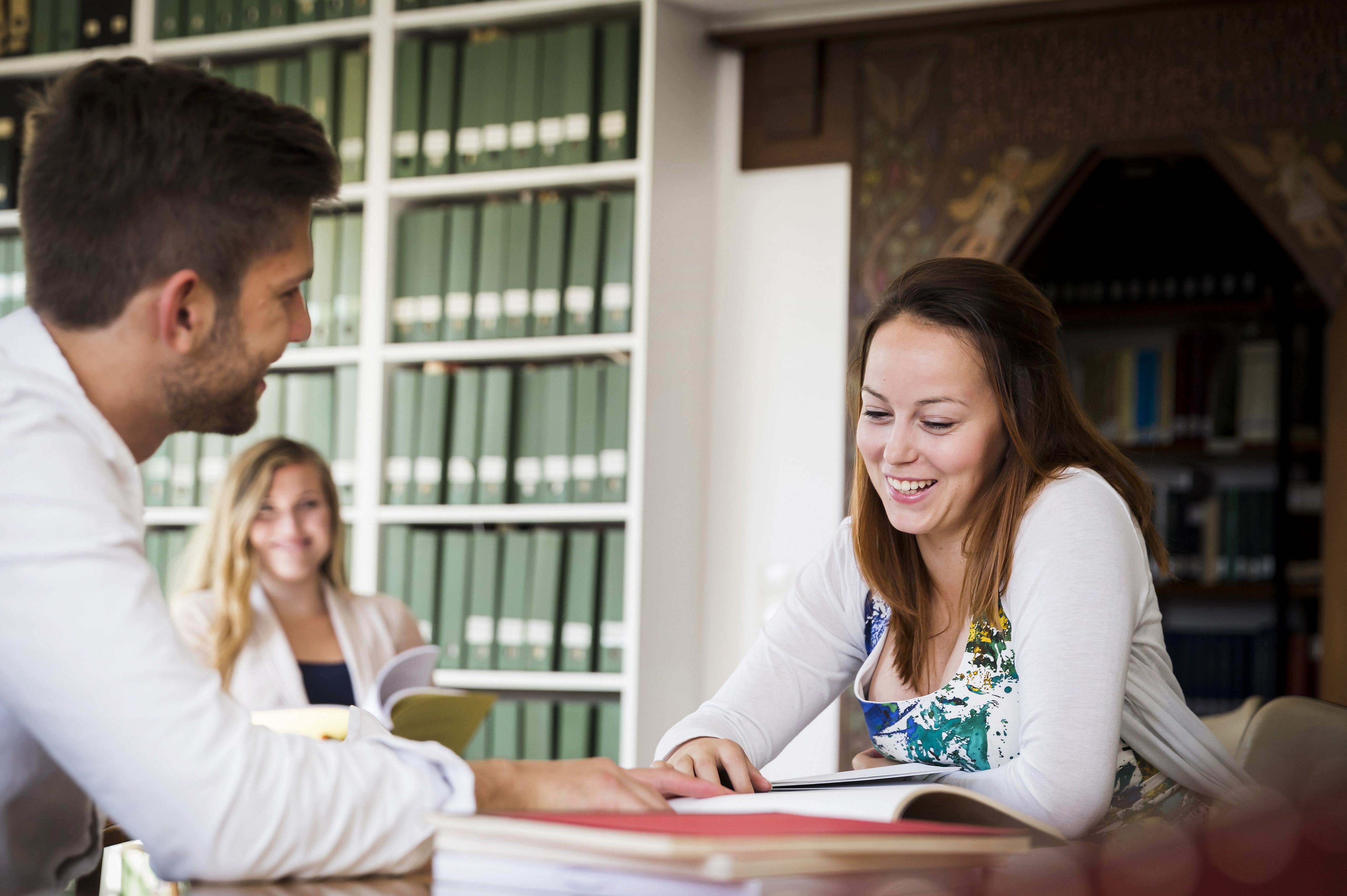 3 students study in a library